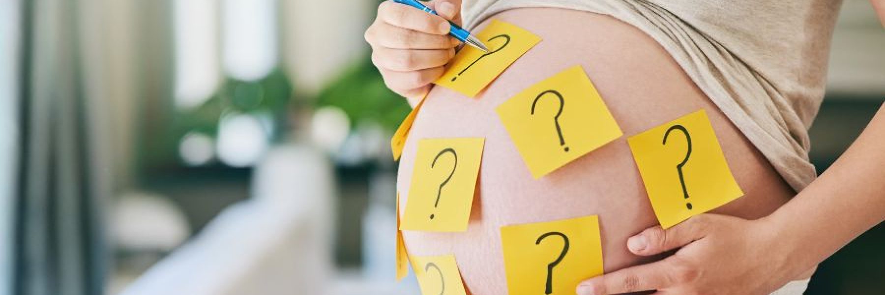 mulher-gravida-desenhando-pontos-de-interrogacao-na-barriga