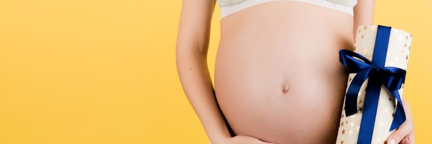 mulher-gravida-segurando-uma-caixa-de-presente-e-tocando-a-barriga_79075-12255